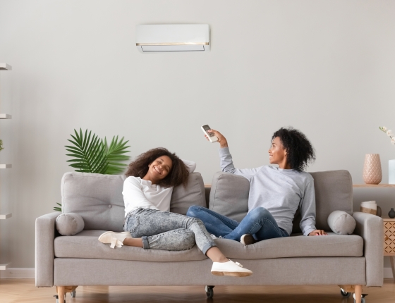 residents adjusting a wall-mounted heat pump unit