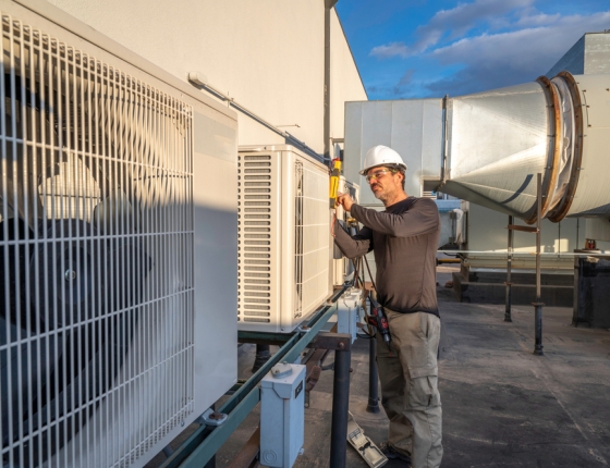 worker adjusting commercial HVAC system