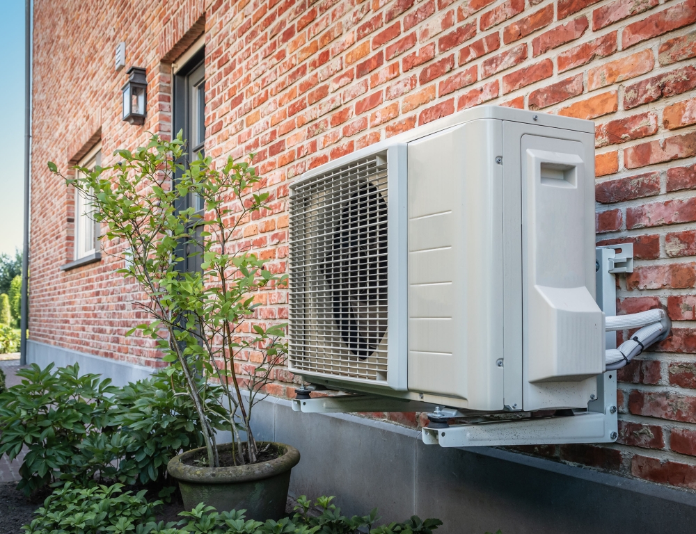 air source heat pump outside next to plant