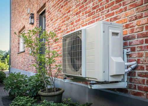air source heat pump outside next to plant