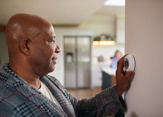 man adjusting thermostat